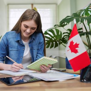 Mujer satisfecha por su trabajo en Canadá. Bandera de Canadá en el escritorio.
