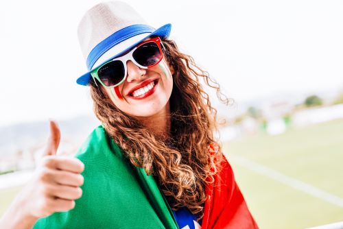 Mujer feliz con bandera de Italia sobre sus hombros
