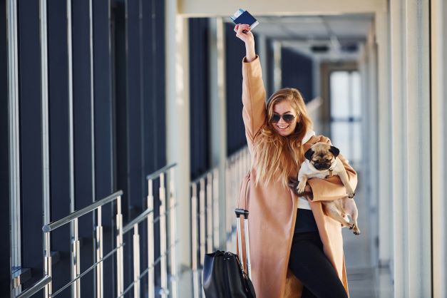 Mujer feliz en aeropuerto con su mascota