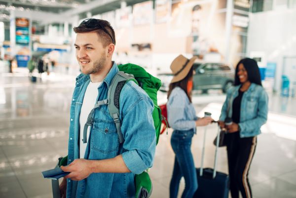 3 personas en un aeropuerto con su pasaporte en la mano