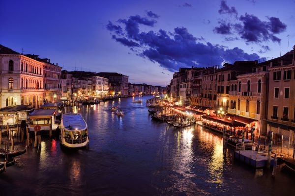 Foto de canal navegable de Venecia durante la noche, en Italia