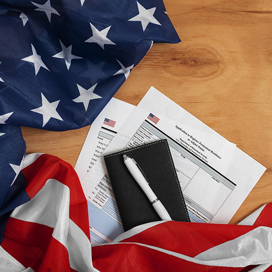 Vista superior de una formularios de solicitud de visa de trabajo en Estados Unidos, bandera, pasaporte y bolígrafo