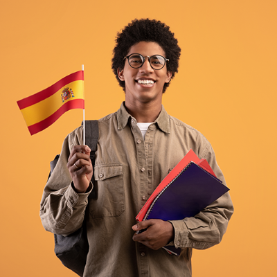 Joven con bandera de España y libros para estudiar